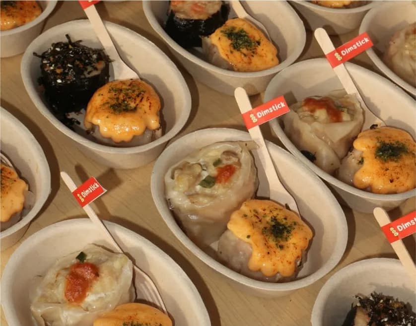 Dimsum jumbo di cup bagasse dengan garpu kayu berlabel Dimstick