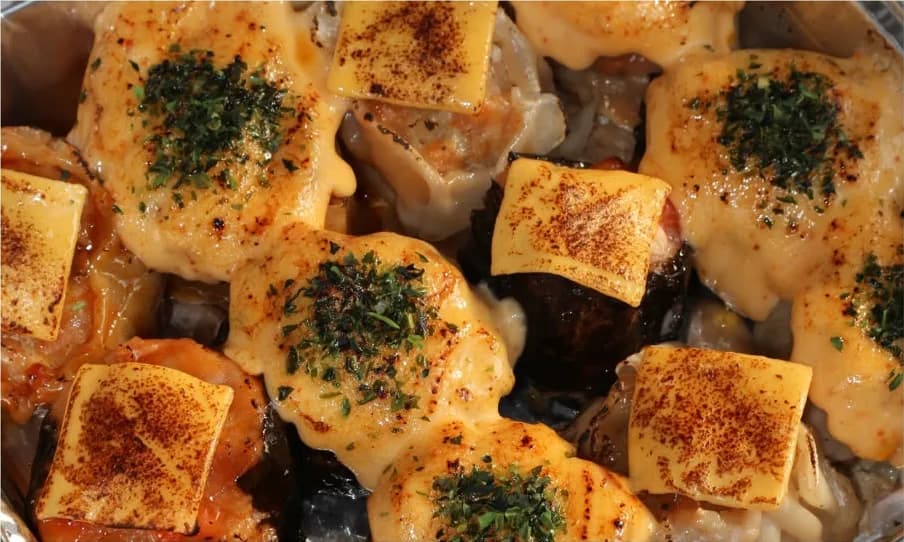 Dimsum jumbo panggang dengan topping keju, mentai, dan nori di dalam tray aluminium